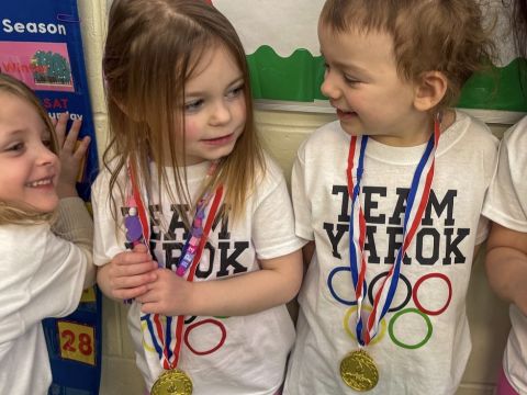Three children in Team Yarok t-shirts and medals