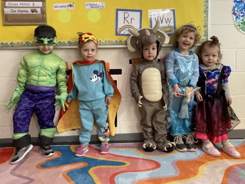 A group of children sat with their teachers - all in costume