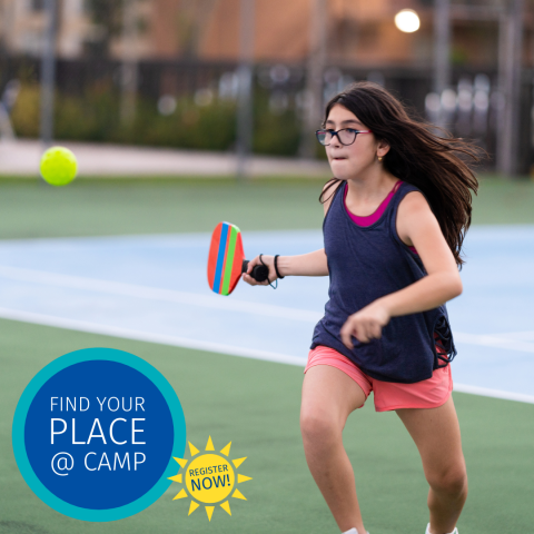 A young girl playing pickleball