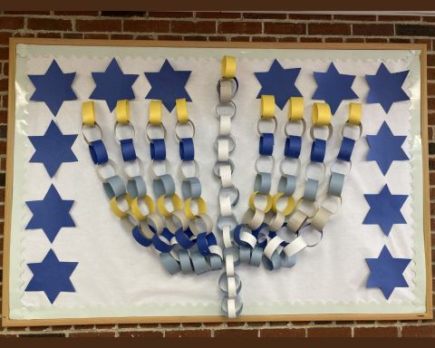 A Hanukkah menorah made from paper chains. displayed on the wall
